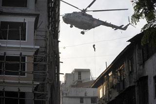 Indian commando comes down a rope to reach the top of Nariman House, a location under siege by suspected militants in Mumbai, India, Friday, Nov. 28, 2008.(Xinhua/AFP Photo)