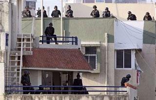 Indian National Security Guards (NSG) commandos prepare to attack from the rooftop of Nariman House in Mumbai.(AFP/Prakash Singh)