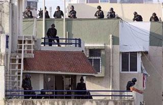 Indian National Security Guards (NSG) commandos prepare to attack from the rooftop of Nariman House in Mumbai.(AFP/Prakash Singh)