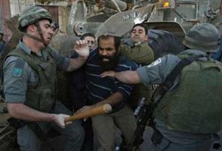 Israeli troops scuffle with a Jewish settler (C) while evicting him from a disputed building in the West Bank city of Hebron December 4, 2008. REUTERS/Baz Ratner
