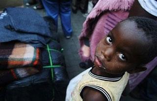 A Zimbabwean infant waits to receive blankets provided by the African Red Cross inAlexandra, South Africa. (AFP/File/Paballo Thekiso)