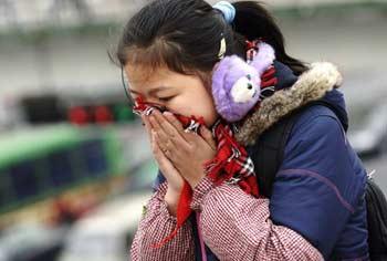 A girl uses her scarf against the cold air in Hefei, East China's Anhui Province, December 4, 2008. Vast areas from north to central China are experiencing a rare strong cold wave front in recent years, which have forced 26 provinces and municipalities to issue cold weather alerts.[Xinhua]