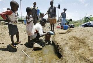 Zimbabwean women and children fetch water from an unprotected well in Harare last month.(AFP/File/Desmond Kwande)