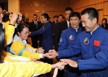 Chinese taikonaut Zhai Zhigang gives souvenir to students during a seminar on the Shenzhou VII manned space mission in China's Macao Special Administrative Region (SAR) Dec. 8, 2008. A delegation of the Shenzhou VII including three taikonauts of the Shenzhou VII space mission Zhai Zhigang, Liu Boming and Jing Haipeng kicked off a three-day visit to Macao on monday. (Xinhua Photo)