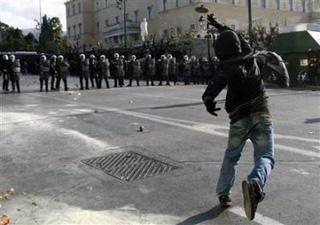 A protester throws a stone at policemen guarding Greece's parliament in Athens December 10, 2008.(Yiorgos Karahalis/Reuters)