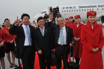 Passengers from southeast China's Taiwan gesture before boarding the plane at the airport in Shenzhen, south China's Guangdong Province, Dec. 15, 2008. A Shenzhen Airlines flight took off from the Shenzhen Airport for Taiwan at 7:20 Beijing Time (2320 GMT Dec. 14), the first when the Chinese mainland and Taiwan started direct air and sea transport and postal services Monday morning.(Xinhua Photo)