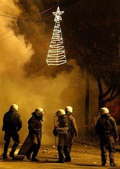 Smoke from tear gas shells billows as riot police officers walk near Christmas decorations during clashes in central Athens, late Saturday, Dec. 20, 2008. Hundreds of rioters battled police in central Athens on Saturday, fire-bombing a credit reporting agency and attacking the city's Christmas tree two weeks after the police shooting of a teenager set off Greece's worst unrest in decades.(AP Photo/Petros Karadjias)