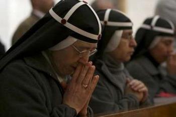 Nuns take part in a mass in the Church of Nativity in the West Bank city of Bethlehem, December 21, 2008. The church is built over the grotto where Christians believe the Virgin Mary gave birth to Jesus.REUTERS/Nayef Hashlamoun (WEST BANK)
