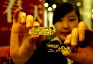 An employee shows two commemorative gold bars of Tuan Tuan and Yuan Yuan leaving for Taiwan in Beijing, capital of China, Dec. 22, 2008. The gold bars for commemoration of Tuan Tuan and Yuan Yuan leaving for Taiwan, manufactured under the supervision of the National Museum of China, were issued Monday. The 4-year-old giant pandas, Tuan Tuan and Yuan Yuan, offered by the Chinese mainland are going to leave for Taiwan Tuesday. (Xinhua Photo)