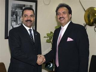 Interpol's Secretary General Ronald Noble, left, shakes hand with Pakistan's Interior Ministry Chief Rehman Malik prior to their meeting in Islamabad, Pakistan on Tuesday, Dec. 23, 2008.(AP Photo/Anjum Naveed)