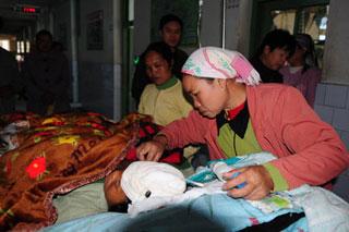 A woman nurses her injured fellow villager in Ruili of Southwest China's Yunnan Province aftert three earthquakes measuring 4.9, 4.3 and 4.0 on the Richter scale hit Southwest China on December 26, 2008. The earthquakes have left 19 wounded and 49,789 affected. [Xinhua]