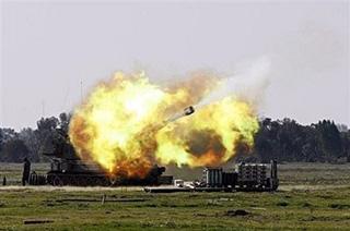 An Israeli army artillery battery fires a smoke bomb into the Gaza Strip from the border. (AFP/Jack Guez)