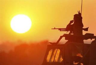 An Israeli soldier gestures atop a mobile artillery unit as the sun sets over the central Gaza Strip January 5, 2009.REUTERS/Gil Cohen Magen