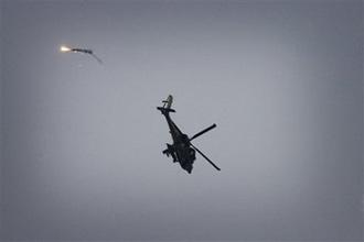 An Israeli attack helicopter fires flares as it operates over the Gaza Strip, seen from the Israel side of the border with Gaza, Sunday, Jan. 11, 2009. (AP Photo/Ariel Schalit)