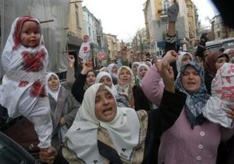 Muslims hold up a doll which represents an injured victim and shout anti-war slogans during a protest by members of the Arab and Muslims communities living in Bulgaria in Plovdiv east of the Bulgarian capital Sofia, Friday, Jan. 9, 2009. Hundreds Muslims gathered to protest against the ongoing Israeli military operation in Gaza Strip.(AP Photo) 