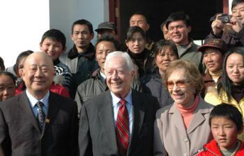 Former U.S. President Jimmy Carter (2nd L, front) and his wife (3rd L, front) pose in front of a local medical center at a village in Hong'an County, central China's Hubei Province, on Jan. 14, 2009. (Xinhua/Wei Mengjia)