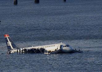 Passengers stand on the wings of a US Airways plane as a ferry pulls up to it after it landed in the Hudson River in New York, January 15, 2009.[Agencies]