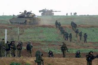Israeli tanks provide security to soldiers returning to Israel early morning January 18, 2009 after a combat mission in Gaza.REUTERS/Yannis Behrakis
