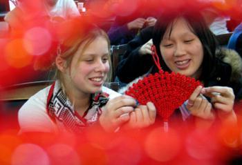 Two New Zealand students learn weaving a Chinese knot in Shandong Normal University in Jinan, capital of east China's Shandong Province, Jan. 19, 2009. A total of 18 students from New Zealand studying at the college learned Chinese folk custom ahead of the traditional Spring Festival, which falls on Jan. 26 this year. (Xinhua Photo)