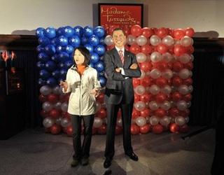 A television reporter speaks next to a wax work of Barack Obama in Hong Kong on January 20. (AFP/Mike Clarke)