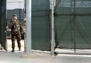 In this photo, reviewed by the U.S. Military, a guard walks through a gate at Guantanamo's Camp 6 detention center, at the U.S. Naval Base, in Guantanamo Bay, Cuba, January 21, 2009.REUTERS/Brennan Linsley/Pool