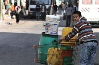 A Palestinian resident with canisters full of water in Gaza City on January 10.(AFP/File/Mahmud Hams)