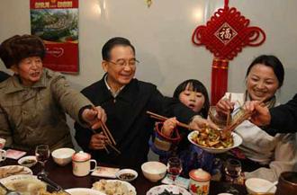 Chinese Premier Wen Jiabao (2nd L) shares the twice-cooked pork slices he cooked with family members of local resident Wu Zhiyuan, in Yingxiu Township of Wenchuan County, southwest China's Sichuan Province, Jan. 25, 2009. Wen Jiabao came to the quake-hit counties of Beichuan, Deyang and Wenchuan in Sichuan Province on Jan. 24 and 25, celebrating the Spring Festival with local residents. (Xinhua/Yao Dawei)