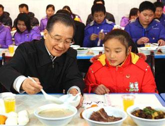 Chinese Premier Wen Jiabao (L) ladles porridge for Zhu Ke, a school girl, at the cafeteria of Beichuan Middle School in Beichuan County, southwest China's Sichuan Province, Jan. 24, 2009. Wen Jiabao came to the quake-hit counties of Beichuan, Deyang and Wenchuan in Sichuan Province on Jan. 24 and 25, celebrating the Spring Festival with local residents. (Xinhua/Yao Dawei)