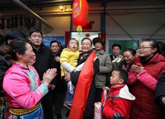 Chinese Premier Wen Jiabao (C) holds a girl in arms during his visit to the residents in Yingxiu Township of Wenchuan County, southwest China's Sichuan Province, Jan. 25, 2009. Wen Jiabao came to the quake-hit counties of Beichuan, Deyang and Wenchuan in Sichuan Province on Jan. 24 and 25, celebrating the Spring Festival with local residents. (Xinhua/Yao Dawei)