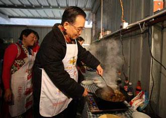 Chinese Premier Wen Jiabao (R) cooks at a kitchen shared by several families at the prefabs in Yingxiu Township of Wenchuan County, southwest China's Sichuan Province, Jan. 25, 2009. Wen Jiabao came to the quake-hit counties of Beichuan, Deyang and Wenchuan in Sichuan Province on Jan. 24 and 25, celebrating the Spring Festival with local residents.(Xinhua/Yao Dawei)