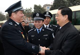 Chinese President Hu Jintao (R) shakes hands with police officer Qiu Eguo at the Kuaizixiang Police Station in Nanchang, capital of east China's Jiangxi Province, Jan. 26, 2009. Chinese President Hu Jintao visited railway staff members, China Mobile branch workers and police officers on duty and ordinary people in Nanchang Jan. 26, the first day of the Spring Festival, or Chinese traditional lunar New Year, to extend his festival greetings. (Xinhua/Ju Peng)