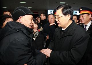 Chinese President Hu Jintao (R Front) shakes hands and talks with a passenger at the Nanchang Railway Station in Nanchang, capital of east China's Jiangxi Province, Jan. 26, 2009. Chinese President Hu Jintao visited railway staff members, China Mobile branch workers and police officers on duty and ordinary people in Nanchang Jan. 26, the first day of the Spring Festival, or Chinese traditional lunar New Year, to extend his festival greetings.(Xinhua/Ju Peng)