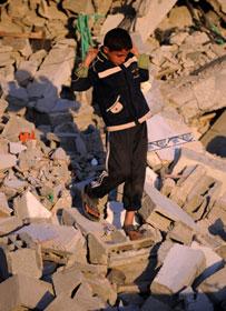 A Palestinian boy searches for belongings in the rubbles of a house in Jibaliya, northern Gaza Strip, Jan. 27, 2009. According to the survey conducted by the Palestinian Central Bureau of Statistics and the UN coordination office for Human Rights, more than 4,000 houses were destroyed, 17,000 others damaged and 90,000 people became homeless, due to the Israeli operation of Cast Lead.(Xinhua/Yin Bogu)