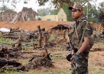 The remains of civillian houses are seen in the background as a Sri Lankan soldier stands guard at Chilawatte in Mullaittivu, the former military headquarters of the Tamil Tiger rebels, on January 27. Sri Lanka's Tamil Tigers have prevented international aid workers from evacuating some 300 hospital patients inside rebel-held territory, a report said Wednesday.(AFP/Ishara S. Kodikara)