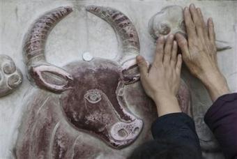 People rub a relief sculpture of an ox at the Taoist White Cloud Temple in Beijing on the third day of Chinese New Year celebrations Wednesday Jan. 28, 2009. Millions across China have been celebrating the arrival of the Year of the Ox, marked with a week-long Spring Festival holiday.(AP Photo/Greg Baker)