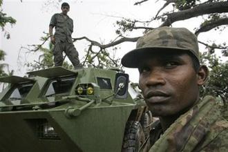 Sri Lankan army soldiers stand guard in the newly recaptured Tamil rebel-held town of Mullaittivu, about 230 kilometers (144 miles) northeast of Colombo, Sri Lanka, Tuesday, Jan. 27, 2009.(AP Photo/Gemunu Amarasinghe)