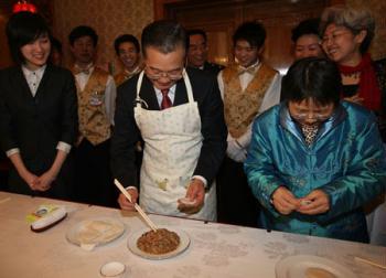 Chinese Premier Wen Jiabao (C, front) makes dumplings with staff members of the Chinese Embassy to Britain, Chinese students studying in Britain, and overseas Chinese in Britain as he visits the Chinese Embassy to Britain in London, Britain, Feb. 1, 2009. Wen is on a three-day official visit to Britain, the last leg of his week-long European tour. (Xinhua/Yao Dawei) 