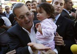 Israel's Defence Minister Ehud Barak holds up a baby girl during a visit in Rishon Le Zion near Tel Aviv February 4, 2009. REUTERS/Gil Cohen Magen