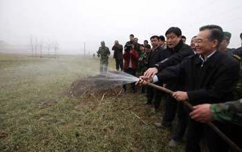 Chinese Premier Wen Jiabao (Front) waters wheat at Donggao Village of Hongchang Township in Yuzhou City, central China's Henan Province, Feb. 7, 2009. Premier Wen inspected the anti-drought work in Henan, one of China's key wheat producing regions, on Feb. 7-8.(Xinhua Photo)