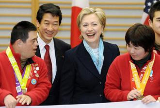 US Secretary of State Hillary Clinton (3rd L) smiles as she poses for photos with athletes of the Special Olympics World Winter Games during a reception after her arrival at Tokyo's Haneda Airport February 16, 2009.[Agencies]