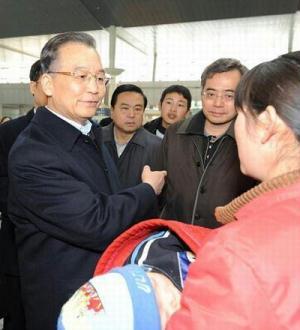 Premier Wen Jiabao talks with the mother of the Leukemia-affected kid Li Rui at the Tianjin Railway Station on his inspection tour in Tianjin on February 16, 2009. [Photo:Xinhua]