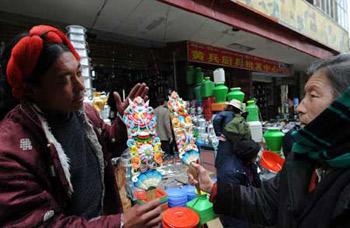 A man sells color plates, which are necessary tools for the Tibetan New Year, at a market in Lhasa, capital of southwest China's Tibet Autonomous Region, Feb. 22, 2009. Traditional goods for the Tibetan New Year are still popular at the market in Lhasa, as the new year draws near. (Xinhua Photo)