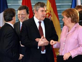 German Chancellor Angela Merkel, right, speaks with Britain's Prime Minister Gordon Brown, center, while EU Commission President Jose Manuel Barroso, second left, chats with French President Nicolas Sarkozy, left, back to camera, prior to a meeting of European leaders at the chancellery in Berlin, on Sunday, Feb. 22, 2009.(AP Photo/Wolfgang Kumm, Pool)