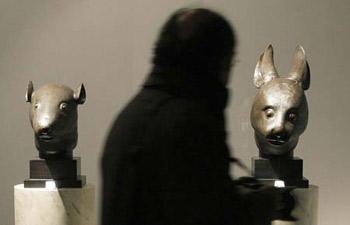 A bronze rabbit head and rat head made for the Zodiac fountain of the Emperor Qianlong's Summer Palace in China are displayed during the exhibition of the private art collection of French fashion designer Yves Saint Laurent and his partner Pierre Berge at the Grand Palais in Paris February 21, 2009.[Photo: Xinhua]
