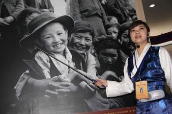 A guide introduces a photo in an exhibition marking the 50th anniversary of the Democratic Reform in Tibet Autonomous Region in Beijing, China, Feb. 24, 2009.(Xinhua Photo)
