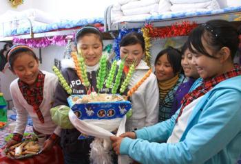 Students of Tibetan ethnic group decorate Qiema, a rectangular wooden box containing roasted barley, and highland barley, which symbolizing great harvest for the coming new year at Liaoyang First High School in north China's Liaoning Province on Feb. 25, 2009. Tibetans across China are celebrating the 50th Tibetan New Year after the Democratic Reform with their old traditions. (Xinhua/Cao Jingyi)