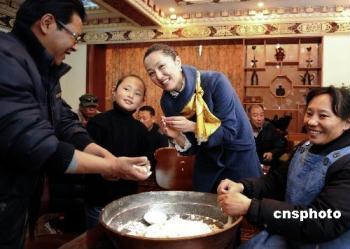 Deqen Yangzom (R, 2nd) with her relatives is making Gutu, a kind of traditional porridge made from different materials, photo from CNS.