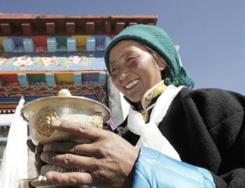 A Tibetan villager toasts during a ceremony for moving into her new house in Kunggar Town of Maizhokunggar County in Lhasa, capital of southwest China's Tibet Autonomous Region, Feb. 11, 2009. Twenty-four families of farmers and herders in Kunggar moved into new houses ahead of Tibetan new year which falls on Feb. 25. Some 312,000 farmers and herders from 57,800 families had moved from shanty homes into new solid brick houses in Tibet in 2008 under a government-subsidized housing project aimed at improving living conditions.(Xinhua/Purbu Zhaxi) 