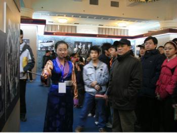 The photo shows a guide showcasing a photo to a group of visitors on the exhibition marking the 50th anniversary of Democratic Reform in China's Tibet Autonomous Region on Wednesday, March 4, 2009. The exhibition opened at the Cultural Palace of Nationalities in Beijing on February 24, and will run through April 10. [Photo: CRIENGLISH.com]