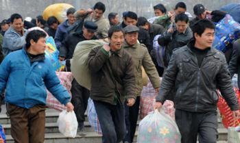 Migrant workers are seen carrying baggages in this photo taken on February 27, 2009, in Zhengzhou, central China's Henan province. [Xinhua]